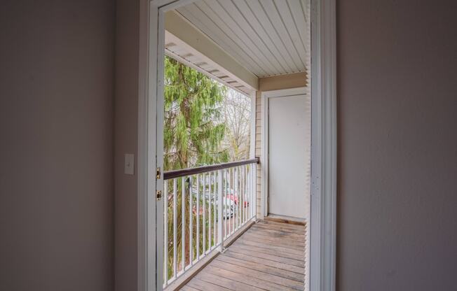the view of a balcony from a room with a door open