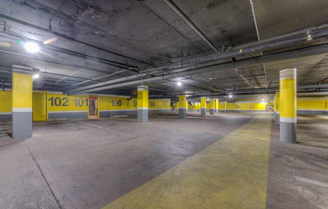 A parking garage with yellow poles and concrete floors.at Iris Luxury Apartments, Memphis