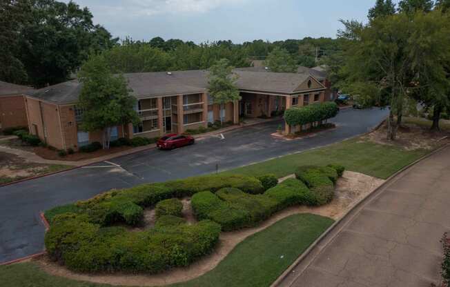 an aerial view of a building with a red car parked in front of it