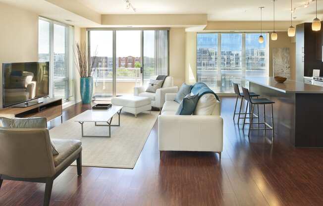 a living room with couches and chairs and a kitchen with a large window