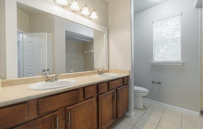 an empty bathroom with two sinks and a toilet