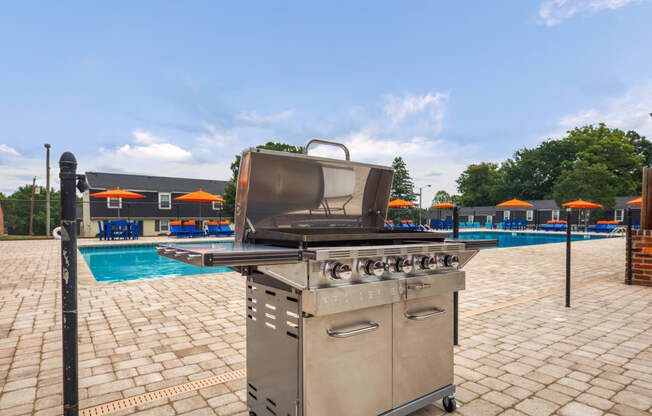 a stainless steel grill next to a swimming pool