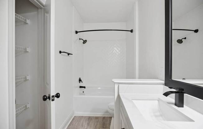 A white bathroom with a walk in shower and a white bathtub.