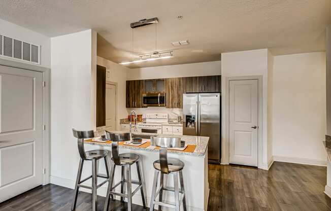 Kitchen with granite countertops, gooseneck faucet, and breakfast bar at EOS in Orlando, FL