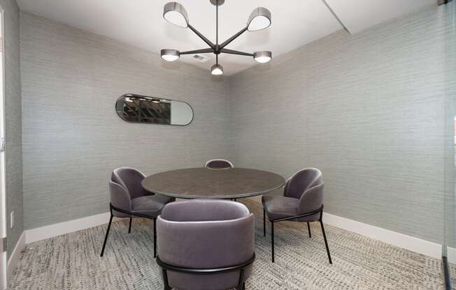 a meeting room with a table and chairs and a chandelier at Track 281 Apartments, California, 95811