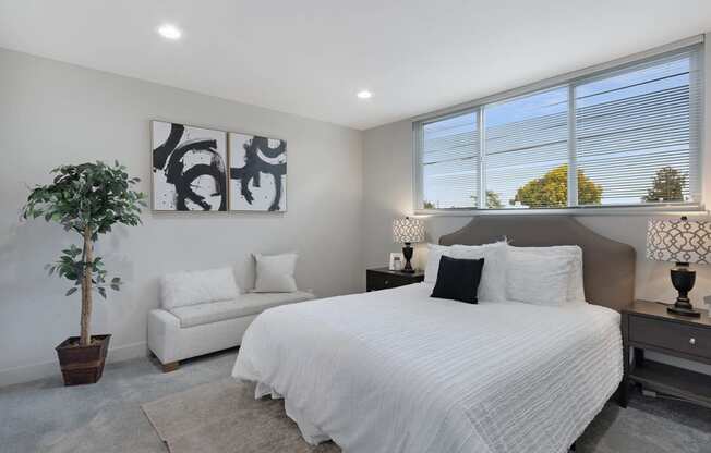 a bedroom with a large bed next to a window