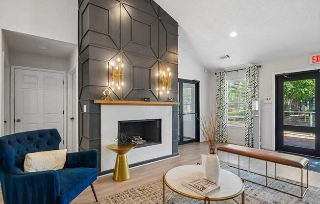 A blue chair sits in front of a fireplace in a well-lit room.