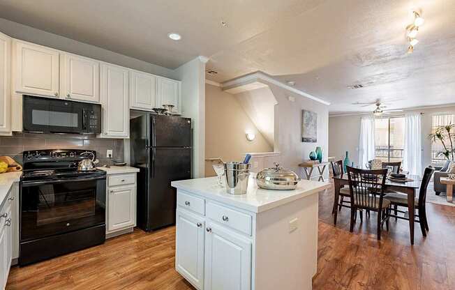 A kitchen with black appliances and white cabinets.at Palazzo Townhomes, Arizona, 85008
