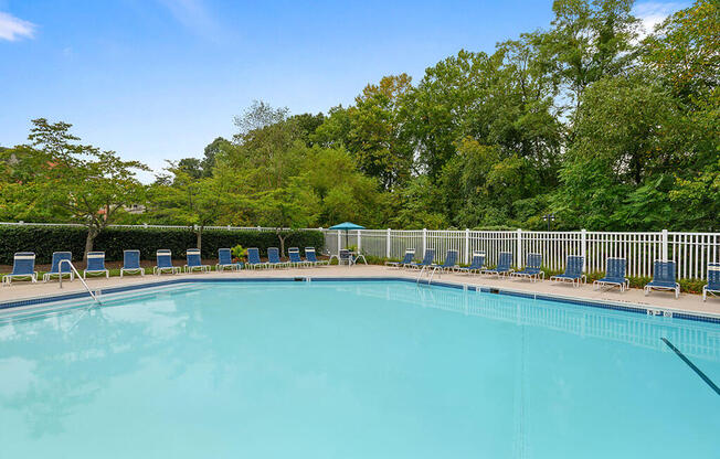 a swimming pool with chairs and trees in the background at ReNew Odenton, Odenton, MD, 21113