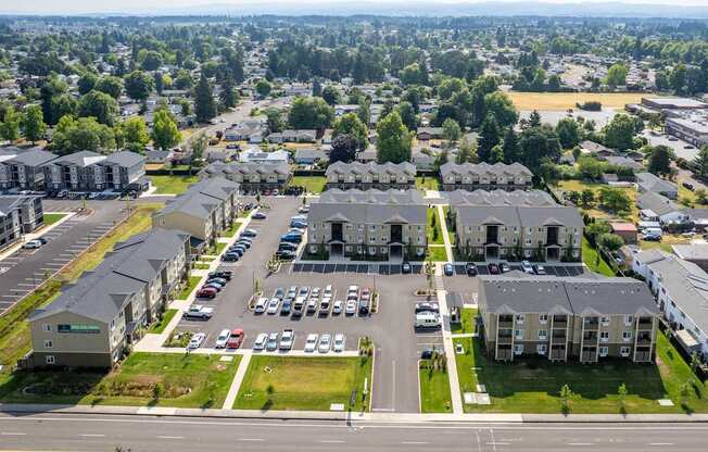 A large apartment complex with a parking lot in front.