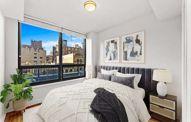 A bedroom with a large bed and a view of the city.