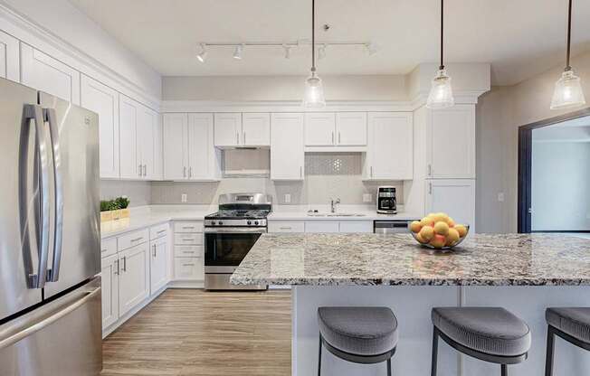 A kitchen with a granite countertop and stainless steel appliances.