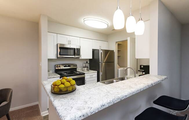 full kitchen with granite counter top and stainless steel appliances at the district flats apartments