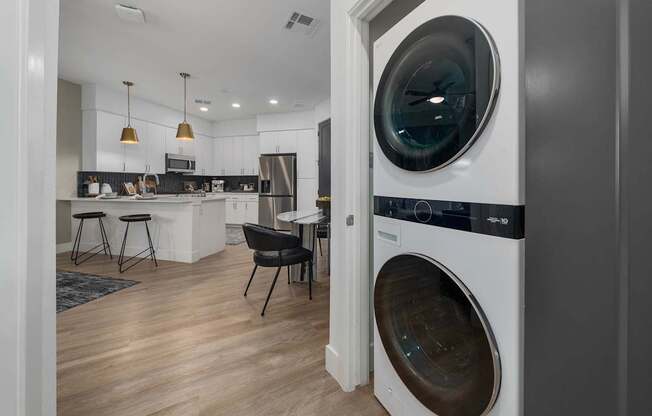 A modern laundry room with a washer and dryer built into the cabinetry.