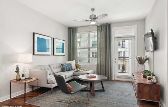 a living room with a white couch and a ceiling fan