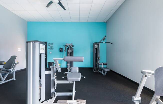 a gym with exercise equipment and a blue wall