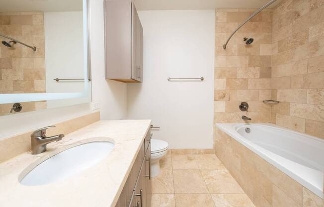 A bathroom with a sink, toilet, and bathtub.