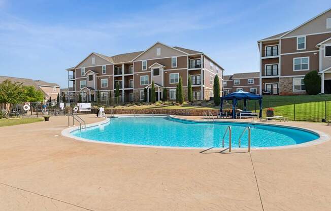 A swimming pool in front of apartment buildings.