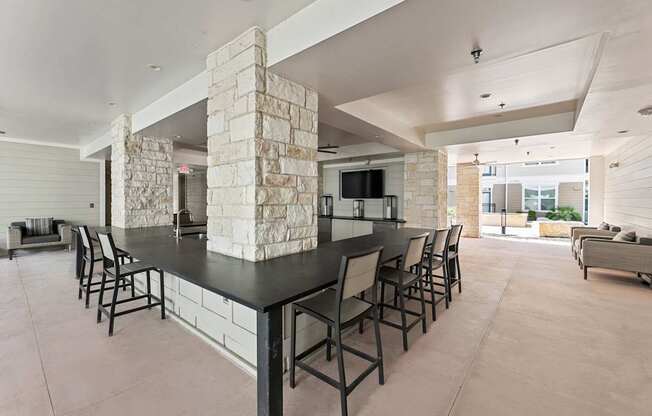 A modern kitchen with a stone pillar and black countertop.