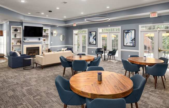 a resident clubhouse with tables and chairs and a fireplace