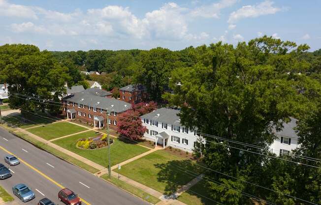 A road with cars and a building with a red roof.