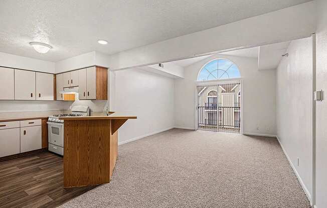 A kitchen with white appliances and a living room with a cathedral ceiling  at West Hampton Park Apartment Homes, Nebraska, 68022