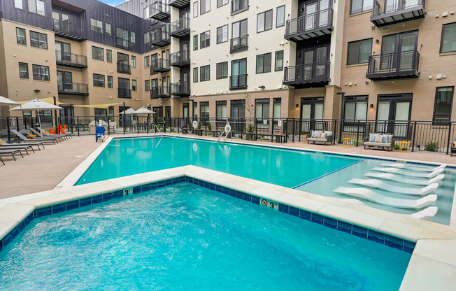 a swimming pool in front of an apartment building