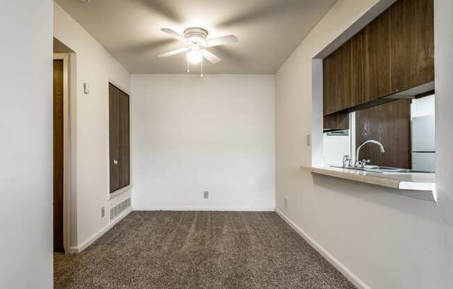 an empty room with a sink and a ceiling fan