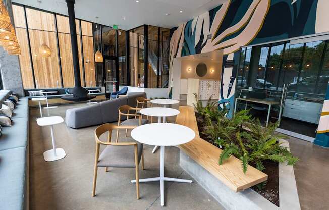 a seating area with tables and chairs in a hotel lobby