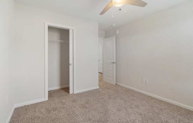 a bedroom with a closet and a ceiling fan