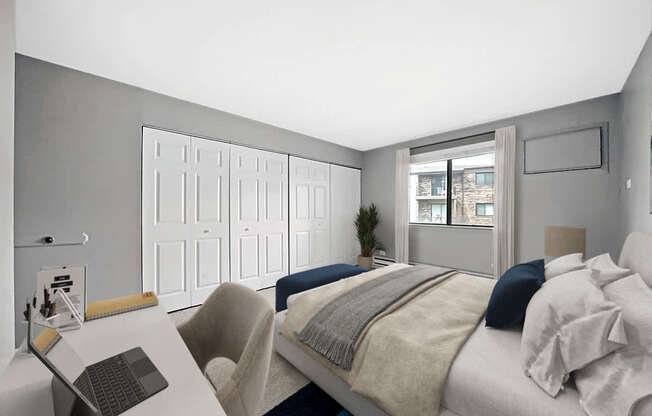 A bedroom with a bed, chair, and desk.