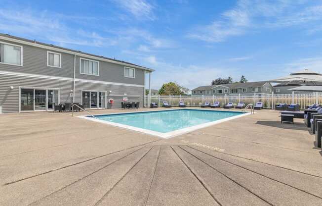 our apartments have a resort style pool with chairs and umbrellas