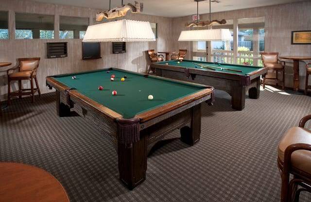 a game room with two pool tables