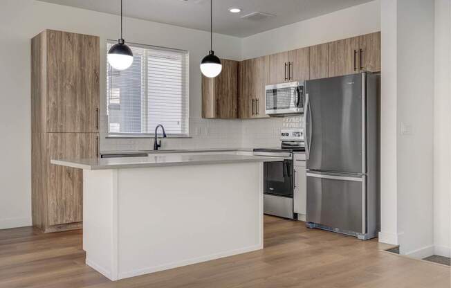 A modern kitchen with a white countertop and stainless steel appliances. at Reveal, Draper, UT, 84020