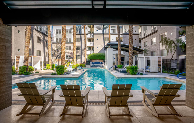 apartments with a swimming pool and lounge chairs