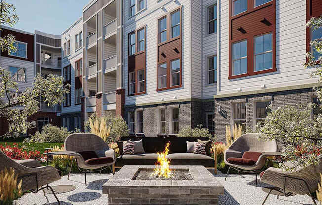 A fire pit sits in the middle of a patio surrounded by chairs and plants.