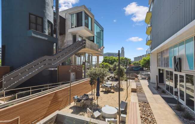 a courtyard with tables and chairs in the middle of buildings