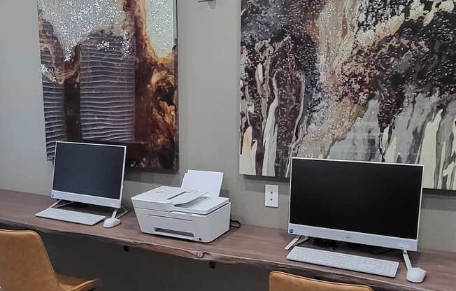 a desk with two laptops and a printer on it