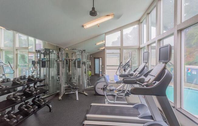 a gym with cardio equipment and windows  at Skyline Heights LLC, Daly City, CA, 94015