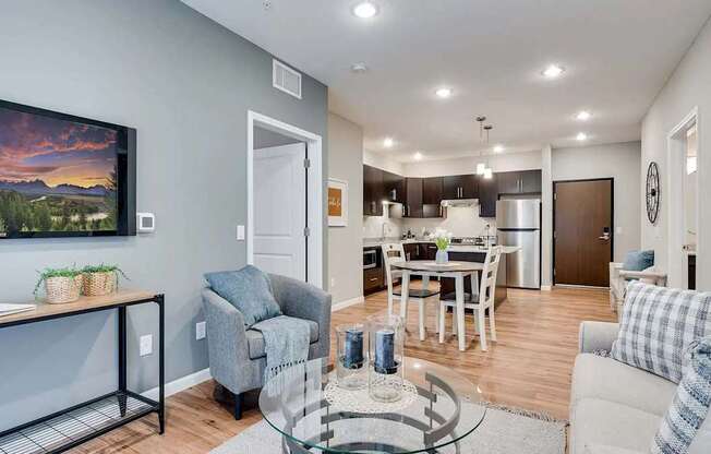 a living room with a couch and a table in front of a kitchen. Circle Pines, MN Lexington Lofts