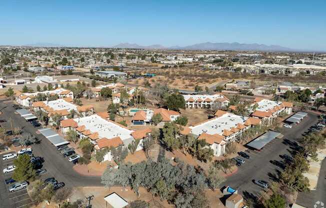 A large housing complex with a parking lot in the foreground.