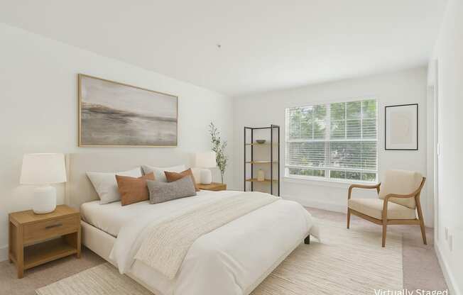 A bedroom with a large bed, a chair, and a painting on the wall.
