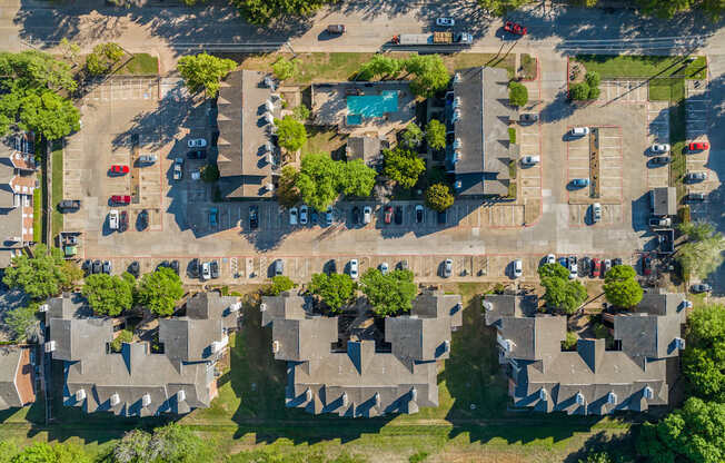 An aerial view of a residential area with houses and cars.