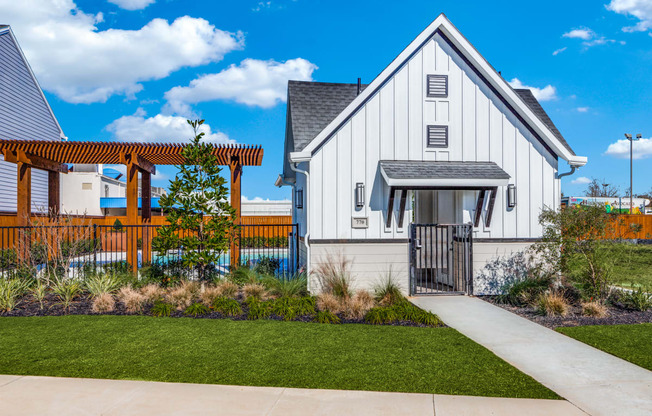 a white home with a walkway and a wooden fence