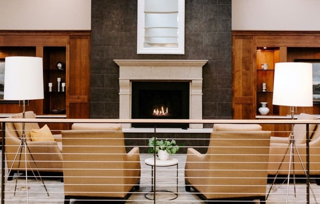 a living room with chairs and a fireplace