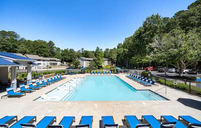A large swimming pool surrounded by blue sun loungers.