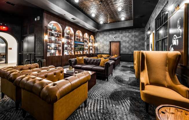 a lounge area with couches and chairs and a wall filled with shelves