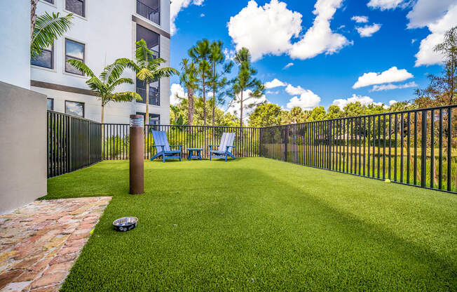a yard with a ball and chairs in front of a fence at Magnolia Square, Naples, Florida