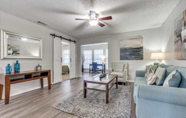 A living room with a blue couch and a wooden coffee table.