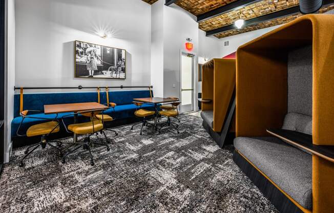 a lounge area with tables and chairs and a television